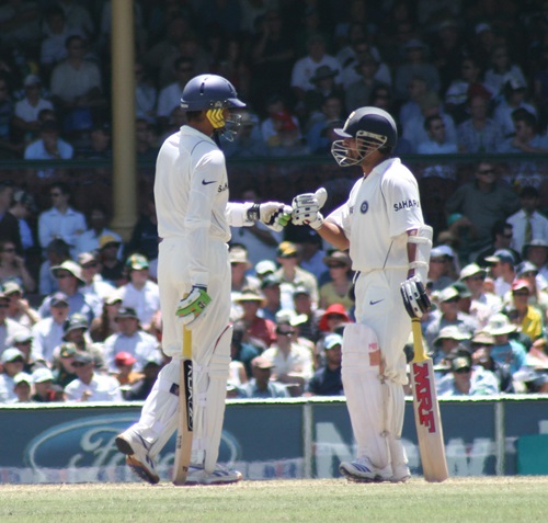 Cricket players in India wearing traditional helmets designed for cooler climates